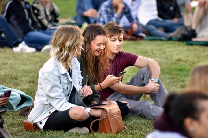 Students sitting outside at a concert
