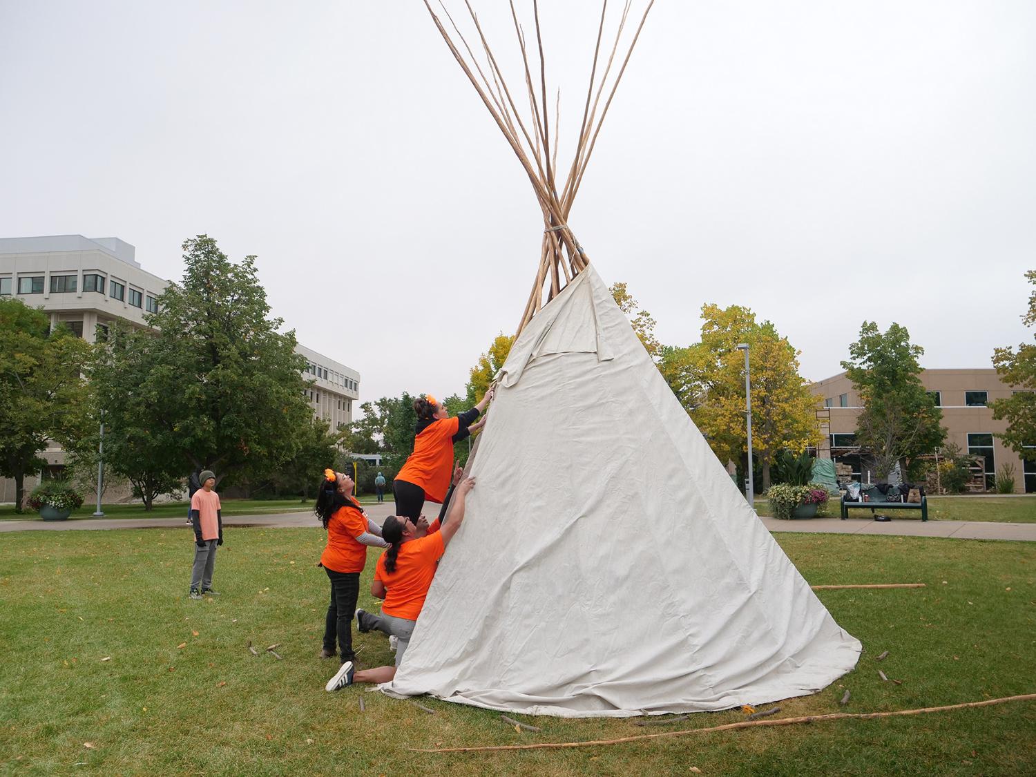 Students putting up tipi poles
