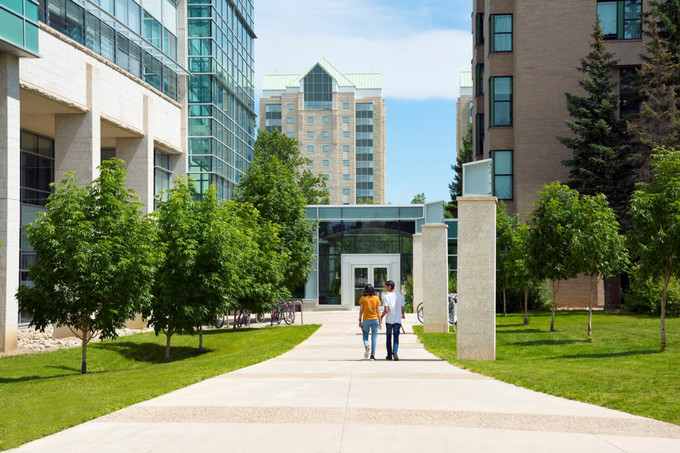 two students walking toward a building on campus