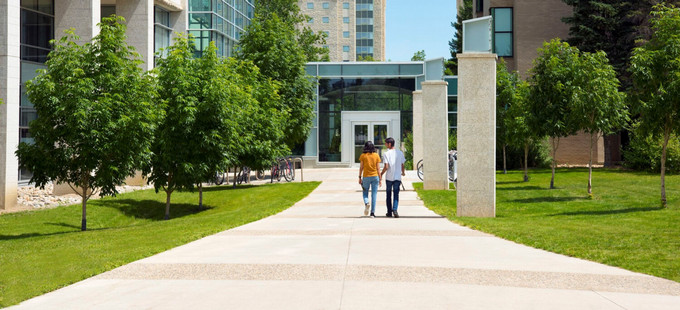 two students walking toward a building on campus