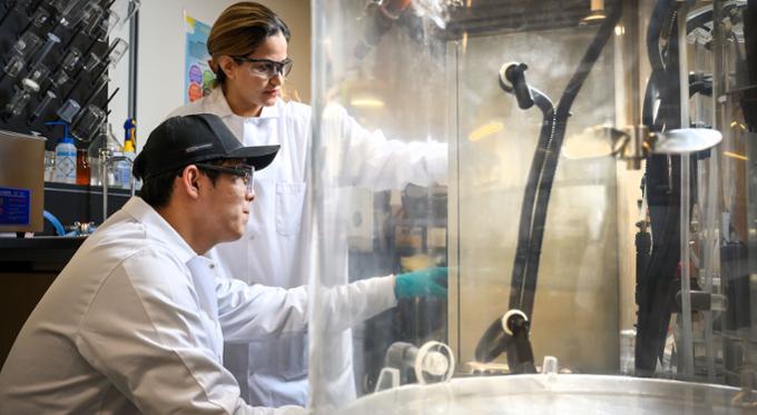 two scientists working on a test in a machine