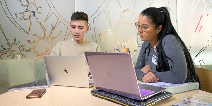 two people working on laptops