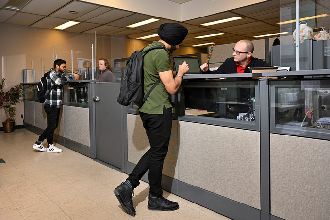 Two people interact at counters in a modern office