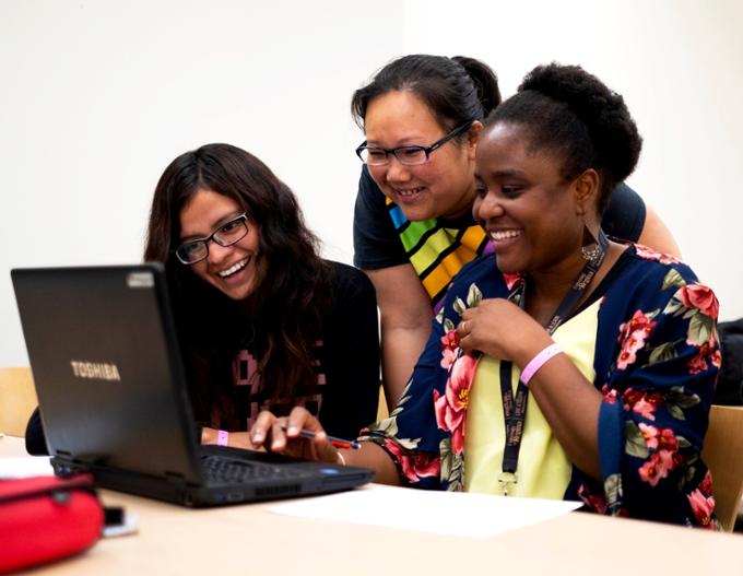 three students looking at laptop
