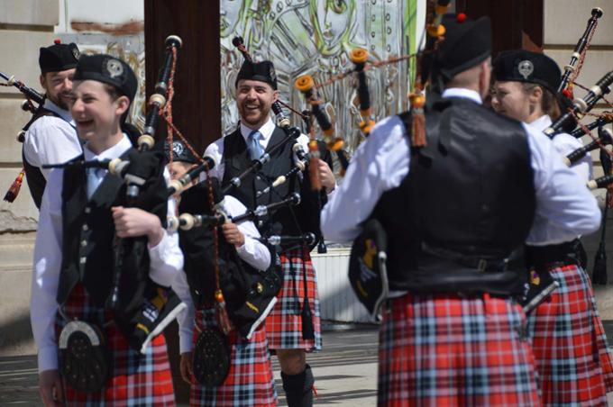 Group of people smiling playing the bagpipes.