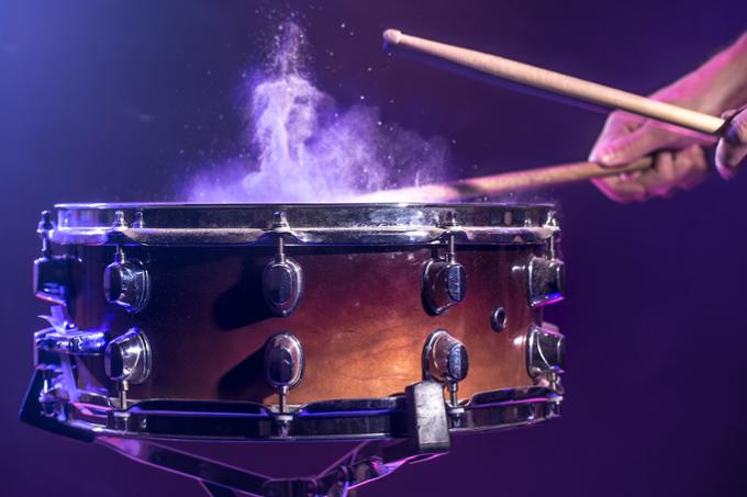 Drum sticks hitting a snare drum.