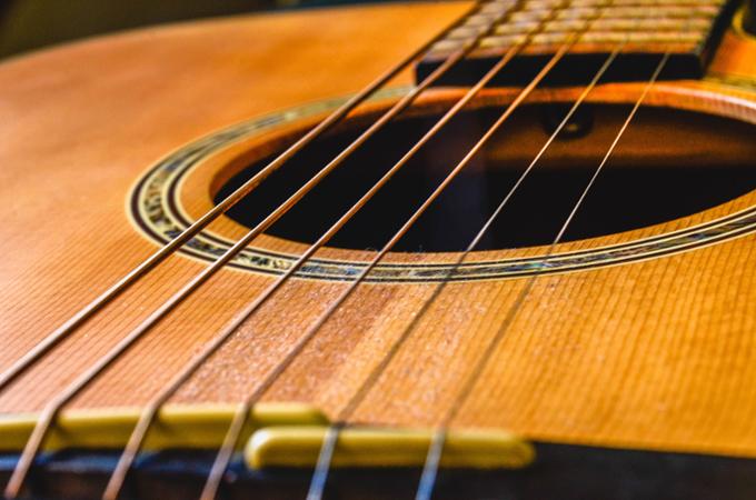 Close up of guitar strings on an acoustic guitar. 