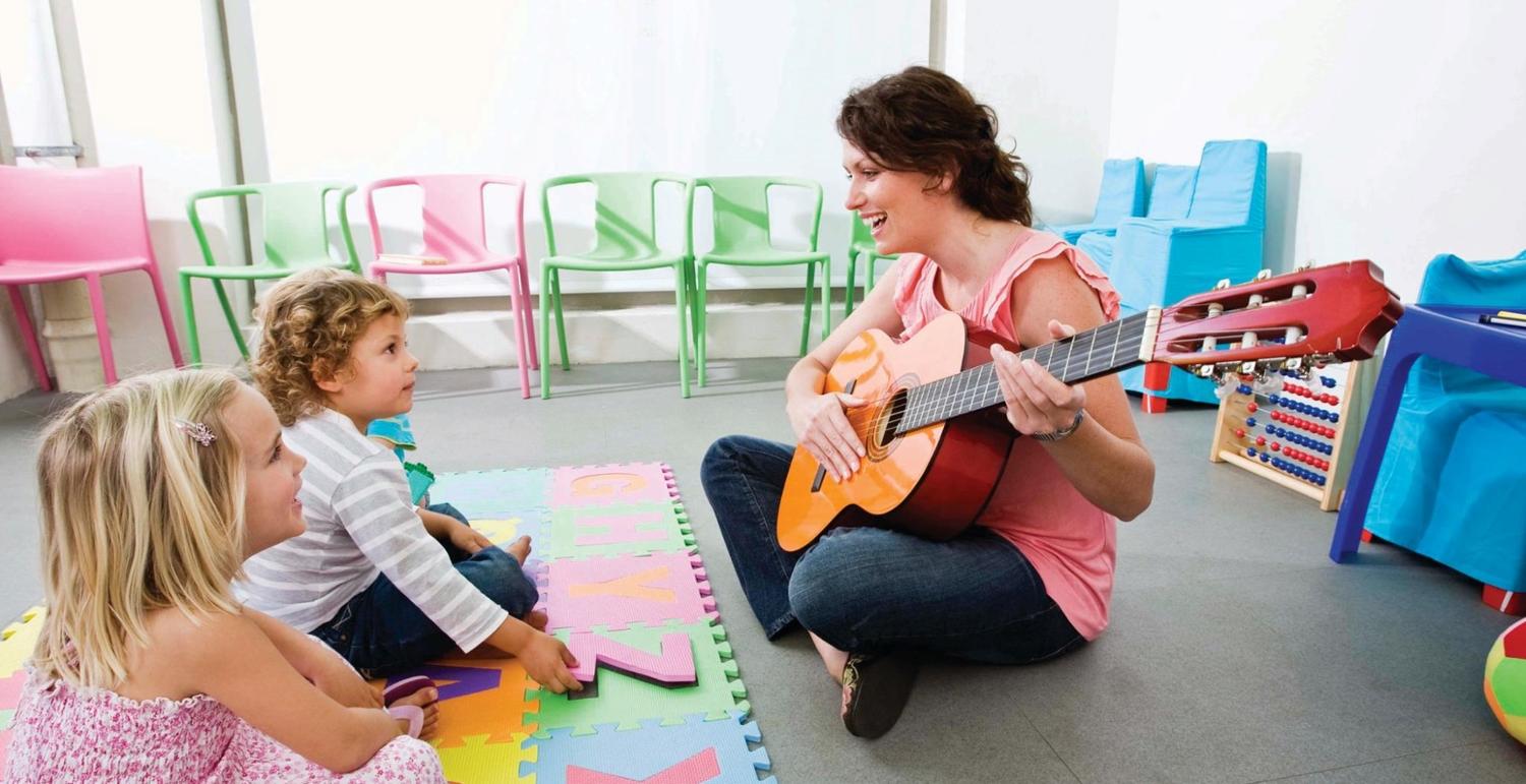 young boy learning to play a string instrument