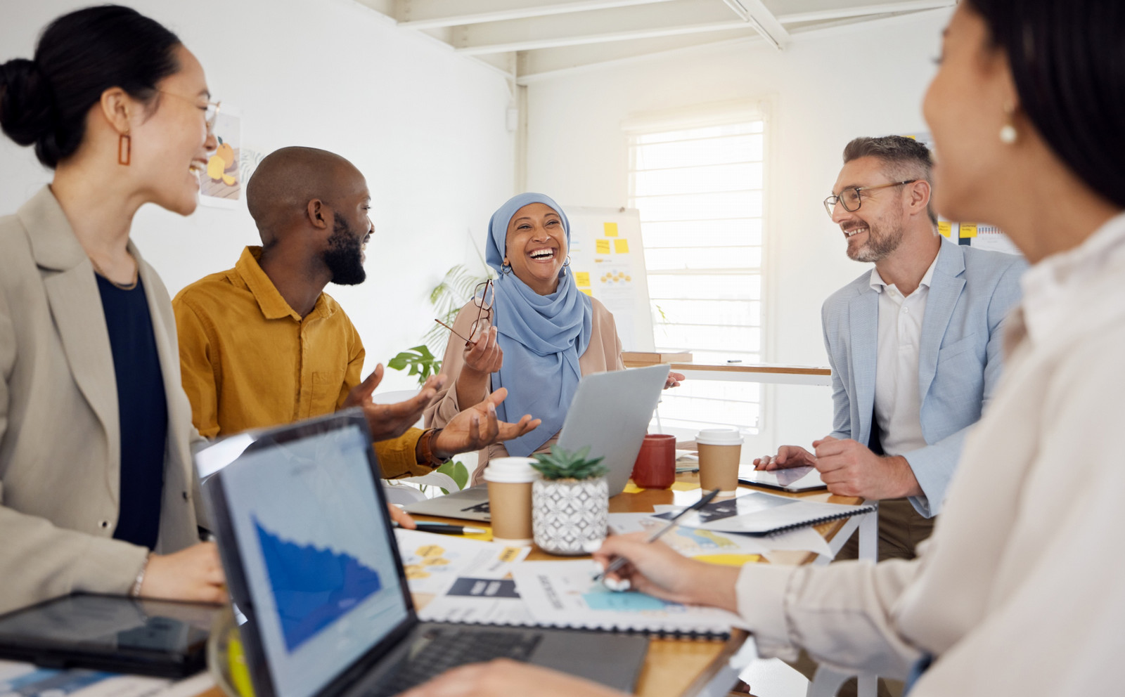 Diverse business team collaborating in modern office, promoting equity, diversity, and inclusion in the workplace.