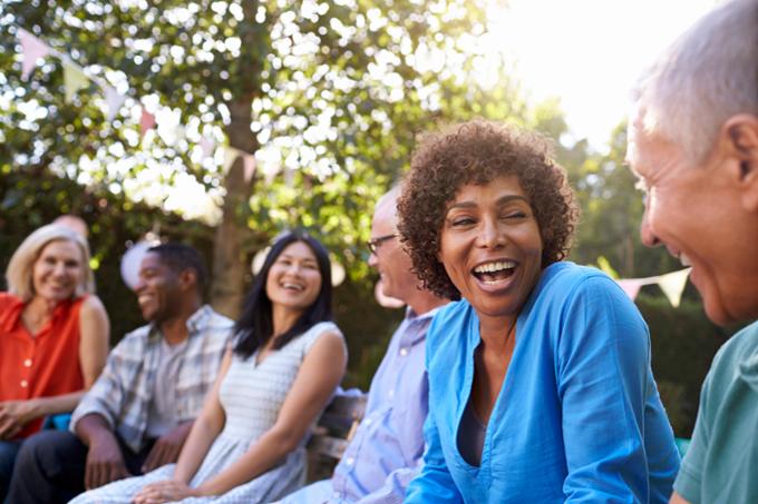 A group of adults chatting and smiling together. 