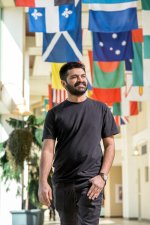 Student walking with flags in background