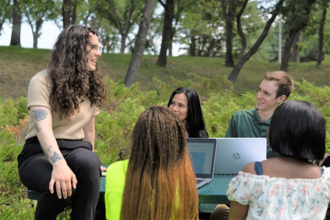 Students outside at picnic table.