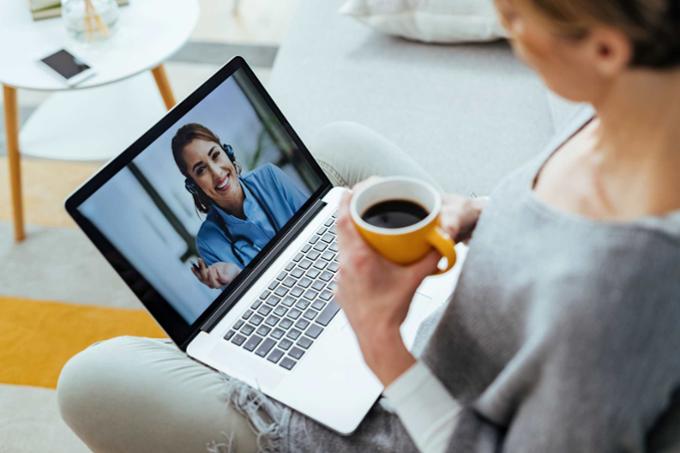 woman holding a coffee and talking with someone online