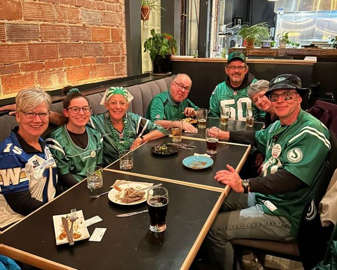 alumni at bar in roughrider jerseys