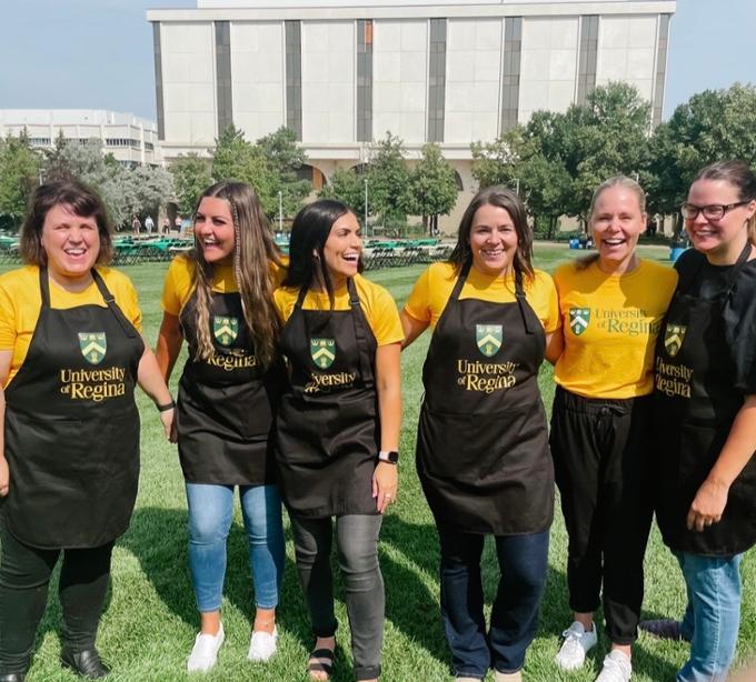 team wearing yellow shirts with black U of R aprons
