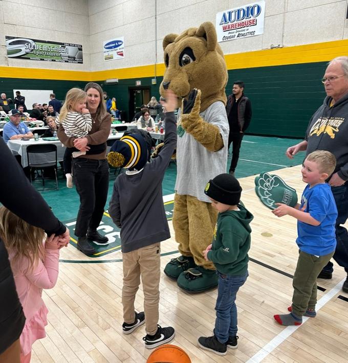 kids high fiving u of r mascot reggie at the slam dunk event
