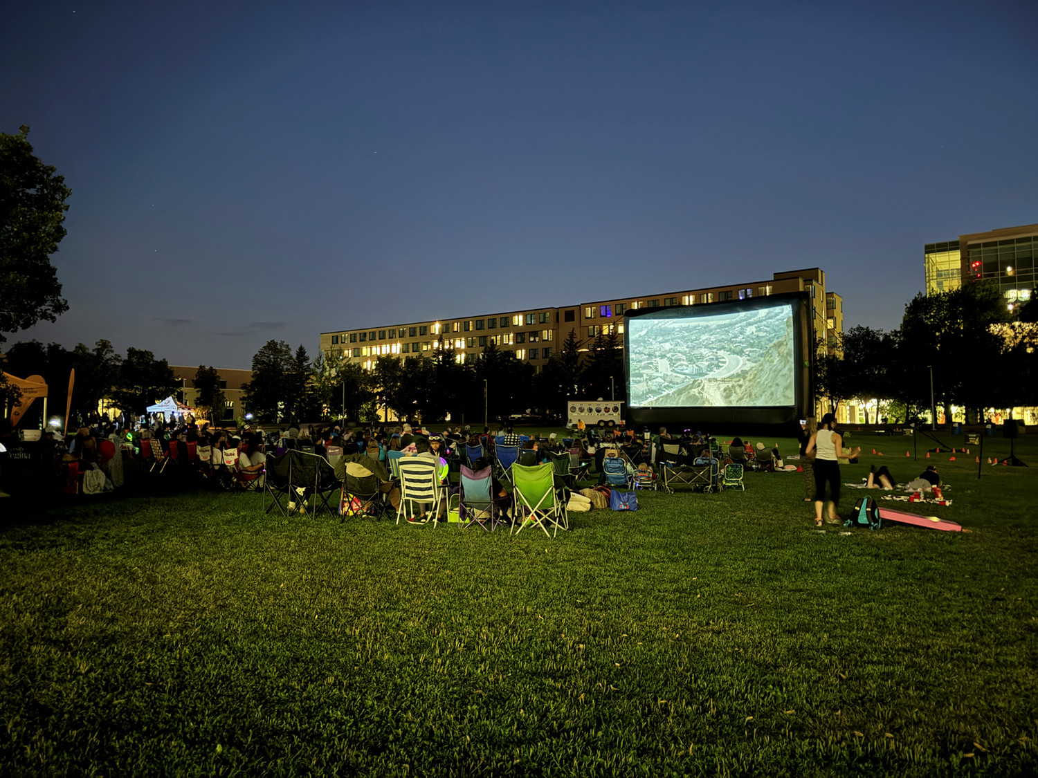 People watching outdoor movie at night