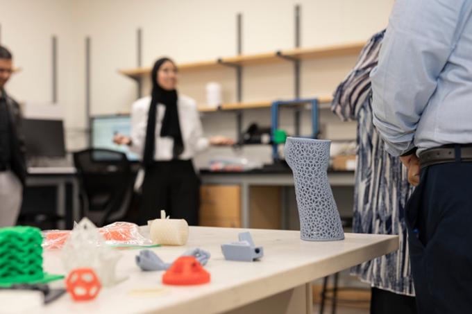 Women speaks in background, focus on colourful objects placed on table