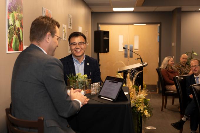 Two men seated on chairs during interview