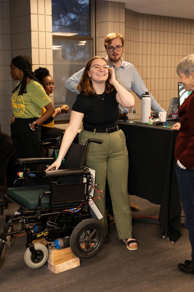 Engineering students stand by automated wheelchair