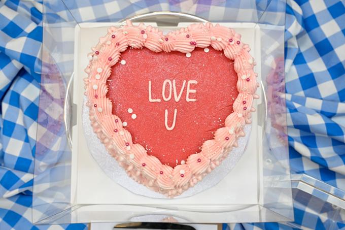 pink and red heart-shaped cake with the words 'love u'