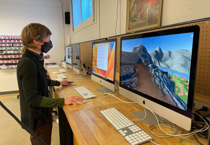 A student stands at a computer station