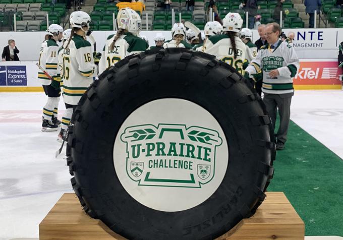 Hockey players shake hands with people standing on a mat at a hockey rink