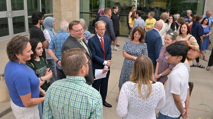 Group of people standing and talking outside.