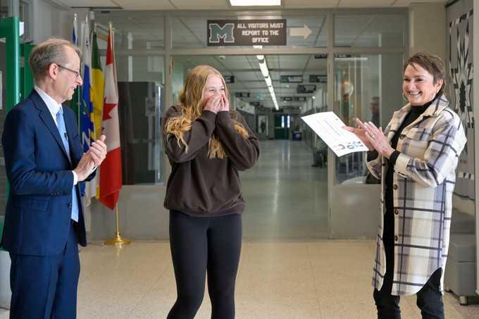 two university officials with a surprised student