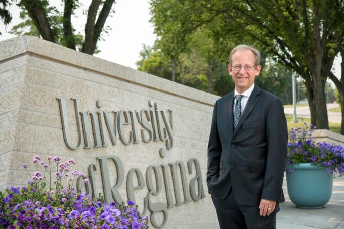 University of Regina President and Vice-Chancellor Dr. Jeff Keshen stands outside by the institutional sign on main campus.