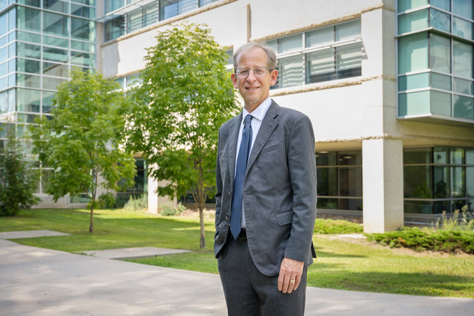 President Jeff Keshen standing outside in front of glass building.