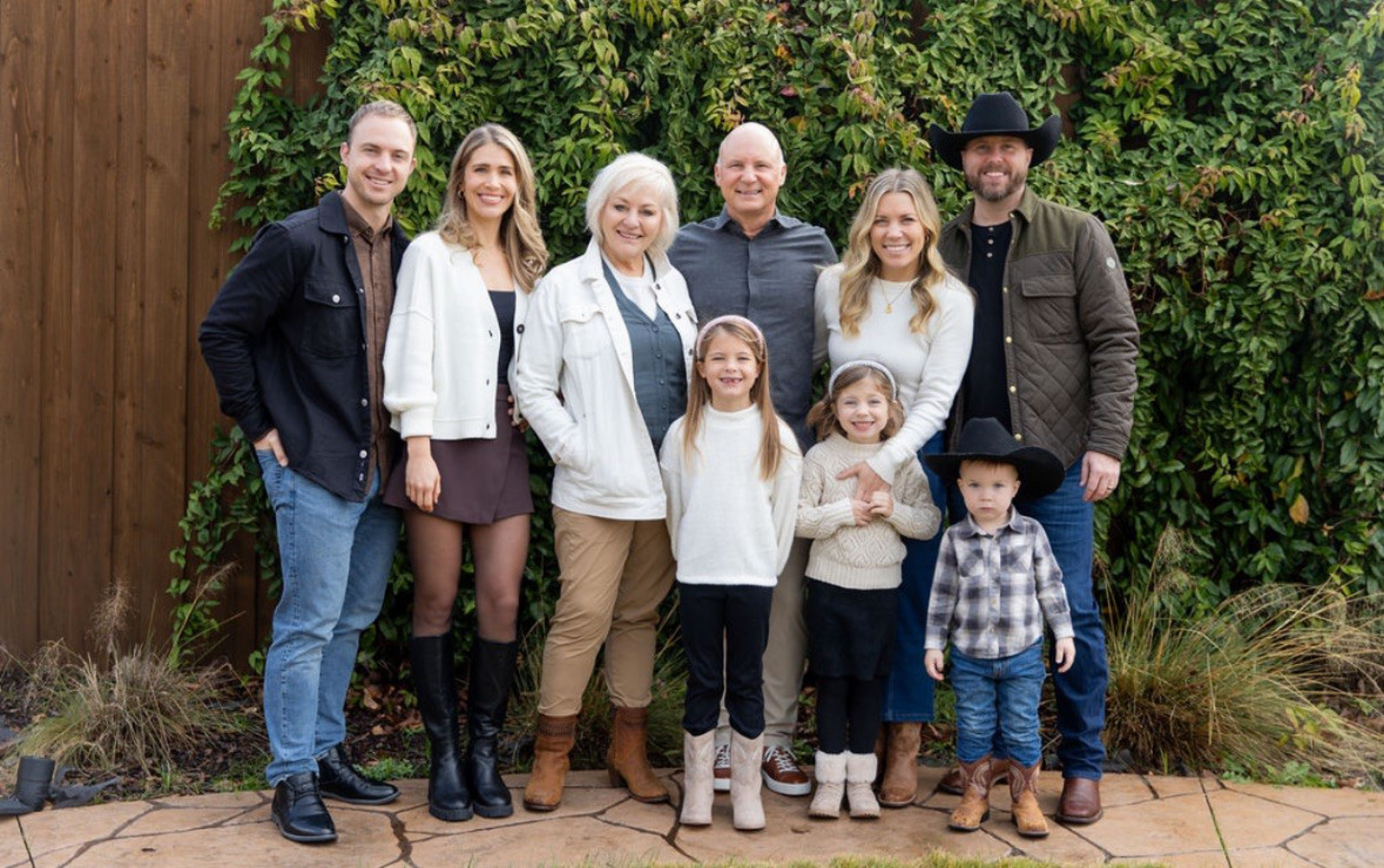 Family photo of nine people standing outdoors.