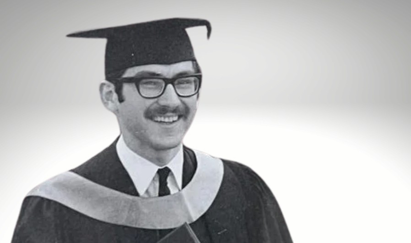 Man in convocation cap and gown.