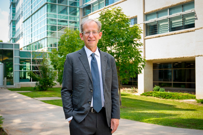 University of Regina President stands outside in front of glass building.
