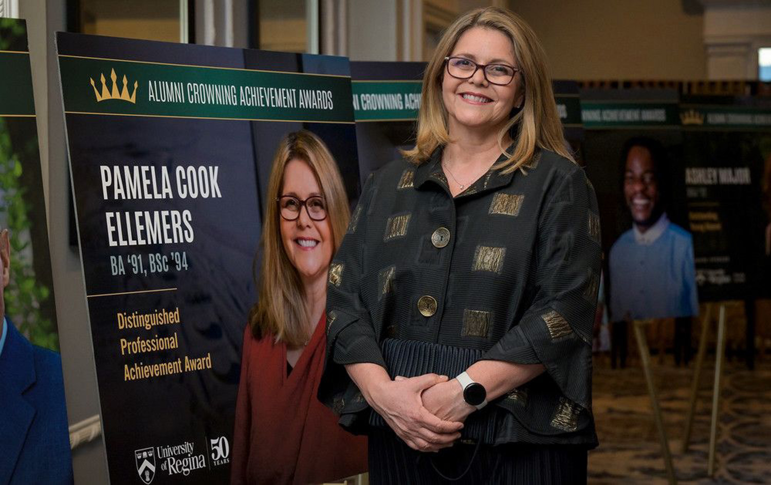 Women in glasses smiles at camera.