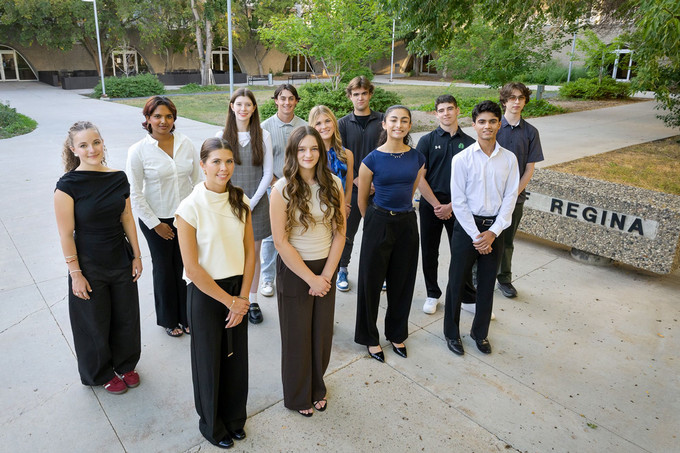 A crowd of young people standing outside smiling.