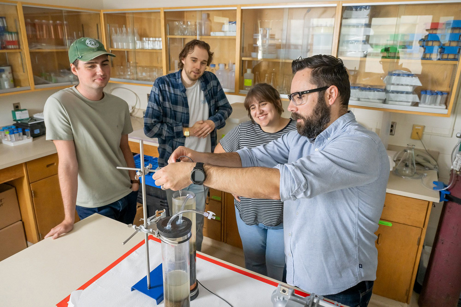 Four individuals standing in a lab with equipment.