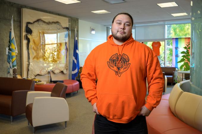 Chad Fisher, new Transition Coordinator at the ta-tawaw Student Centre, stands inside the centre.