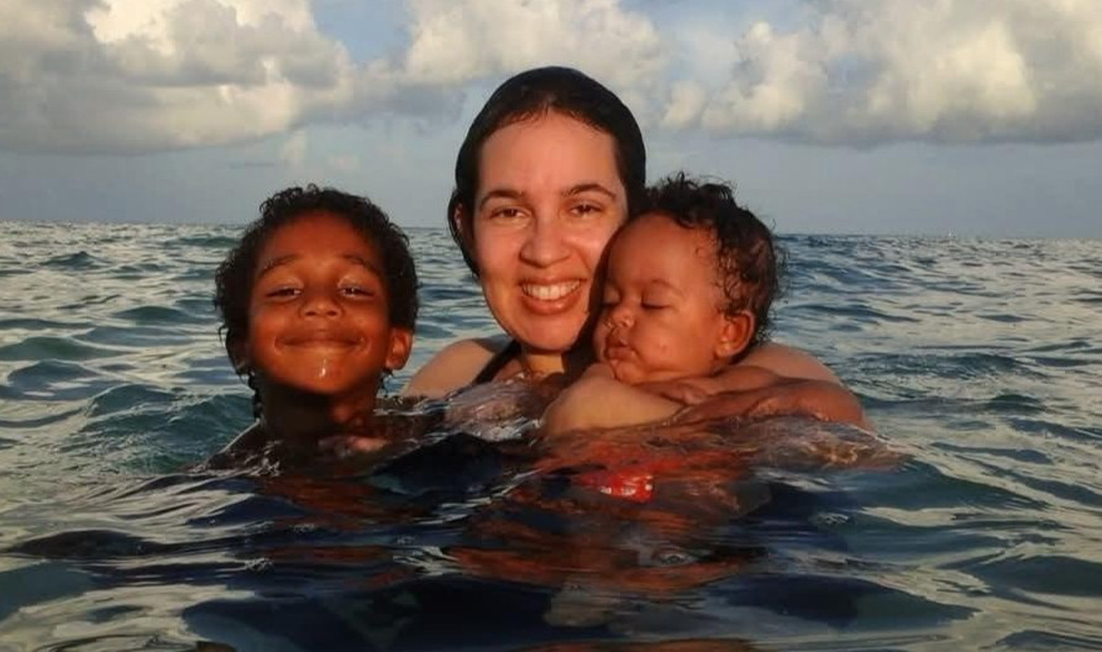 Woman swimming with two children.