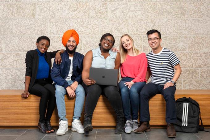 A group of students sitting on a bench.