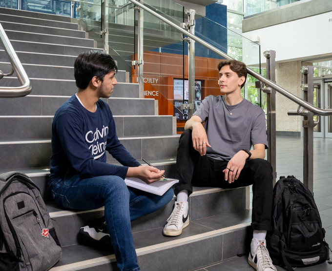 Two people chatting on a staircase