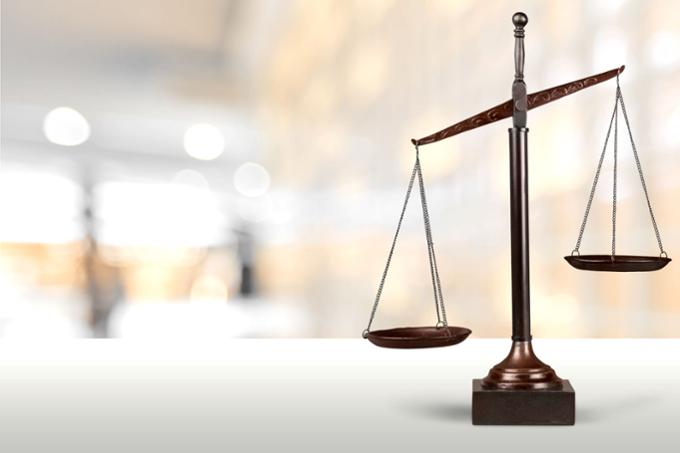 Copper justice scales next to a stack of hardcover books