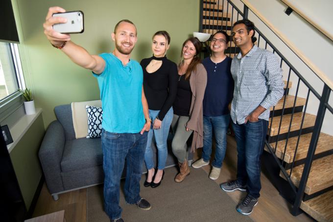 Groups of students taking a selfie next to a staircase.