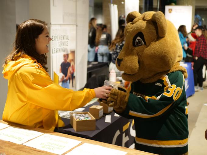 Cougars Mascot Reggie with student in shopping mall.