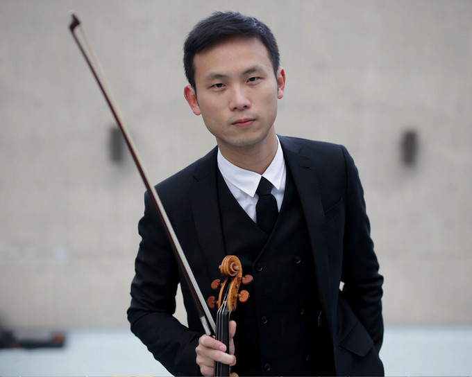 A violin player poses for a photo