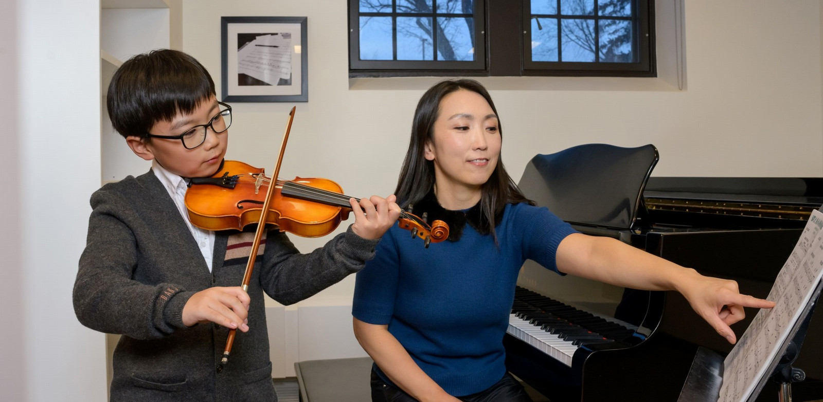 a woman teaching a child the violin
