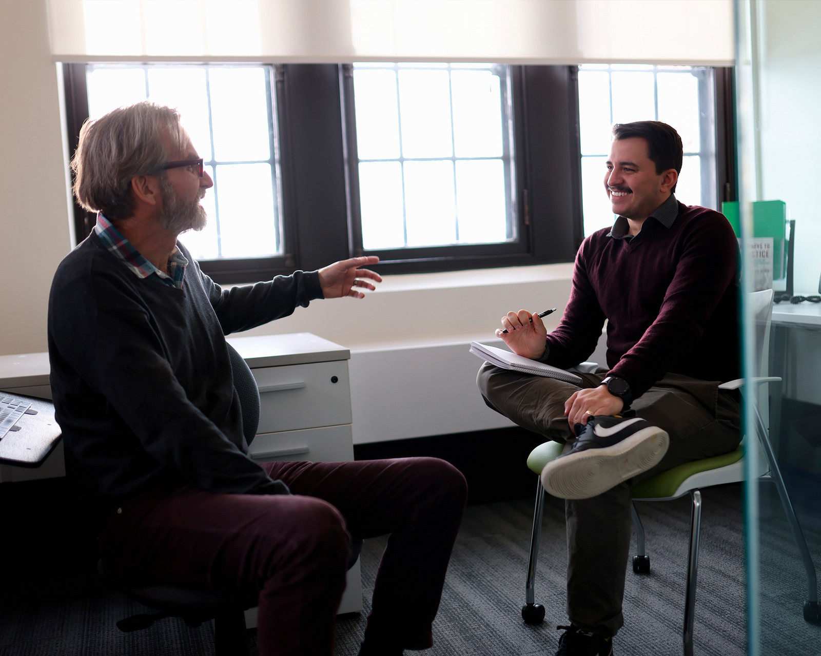 Two men talking in a room together