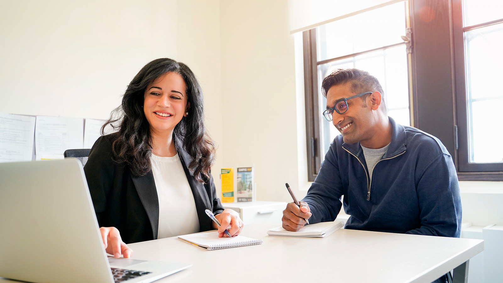 Two people work together at a desk