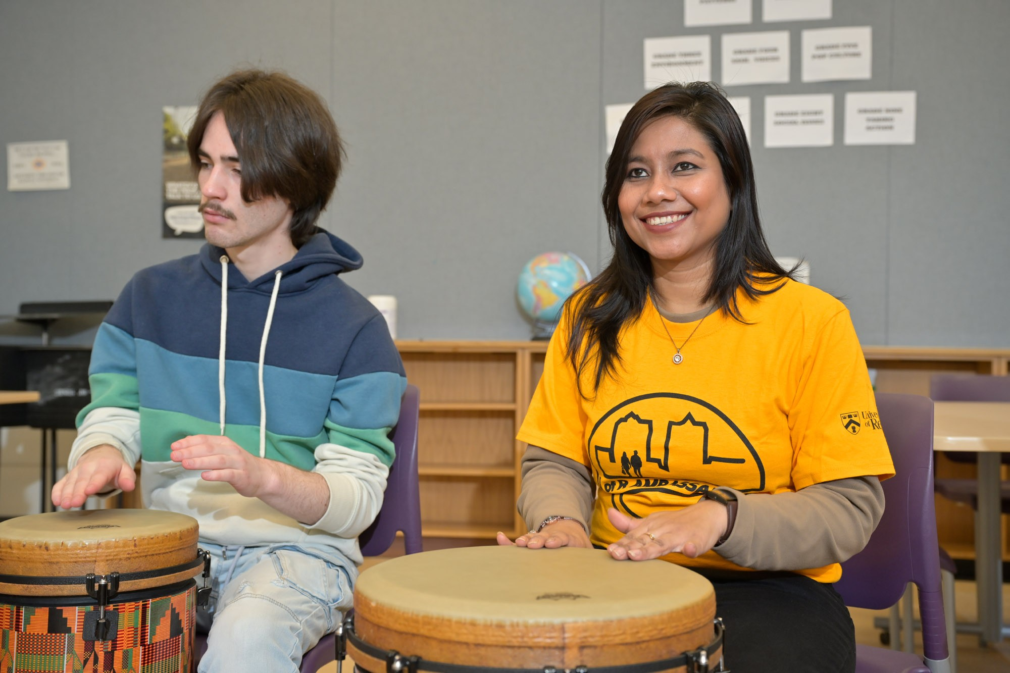 Two people in classroom drumming