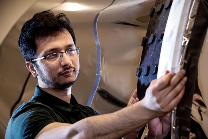 Anwit Adhikari fitting an endoskeleton he designed using a 3D printer onto the mock-up airlock. (Photo by Trevor Hopkin)